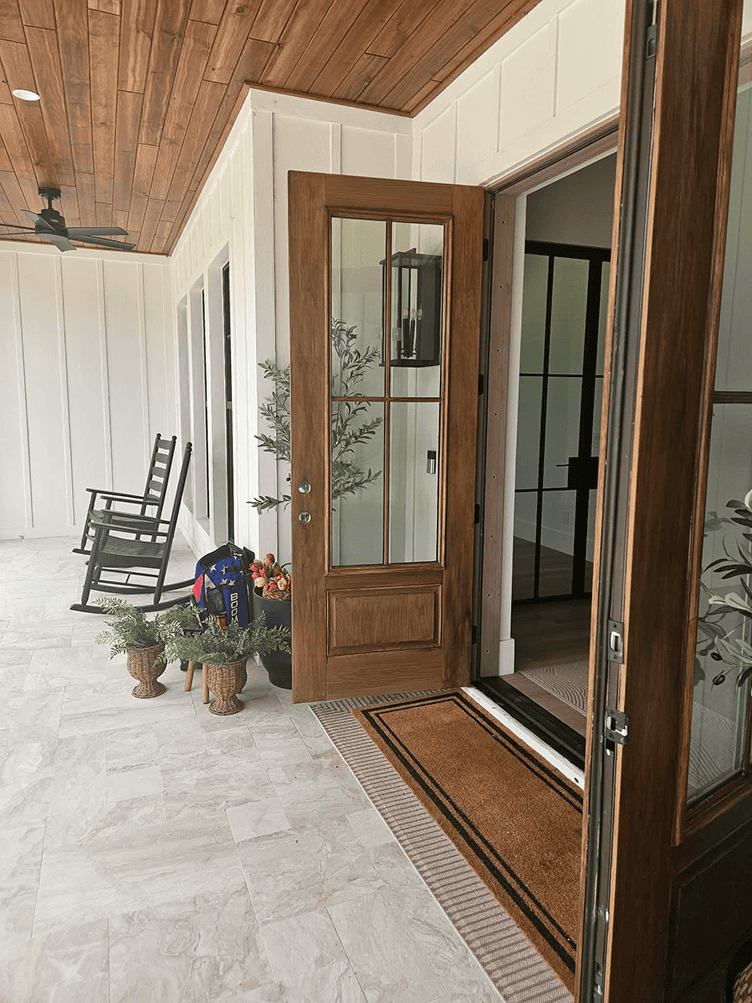 Open wooden front door with rocking chairs