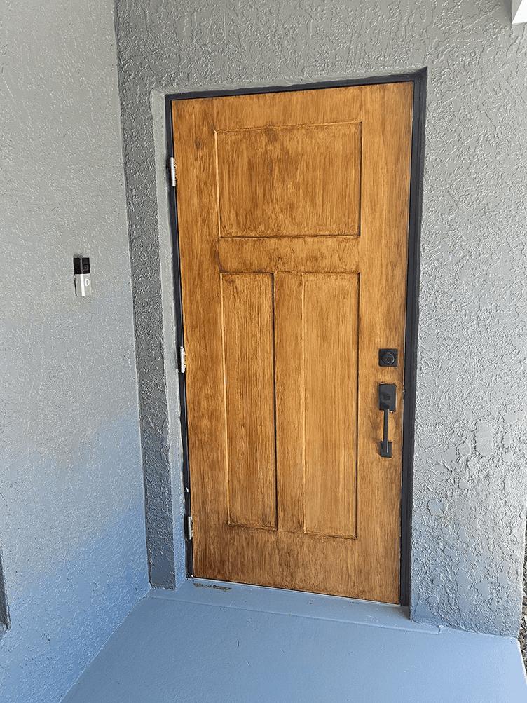 Wooden front door in gray stucco entryway Wooden front door in gray stucco entryway