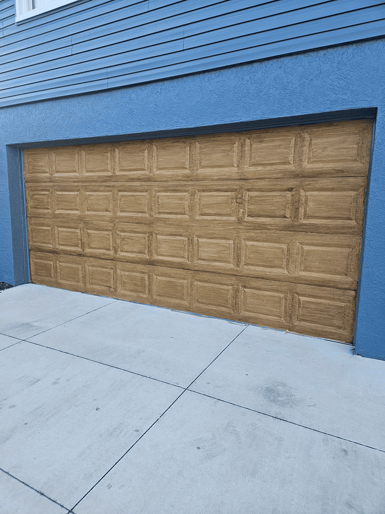 Wooden garage door on blue house Wooden garage door on blue house