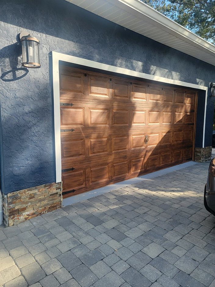 Wooden garage door on blue stucco house Wooden garage door on blue stucco house
