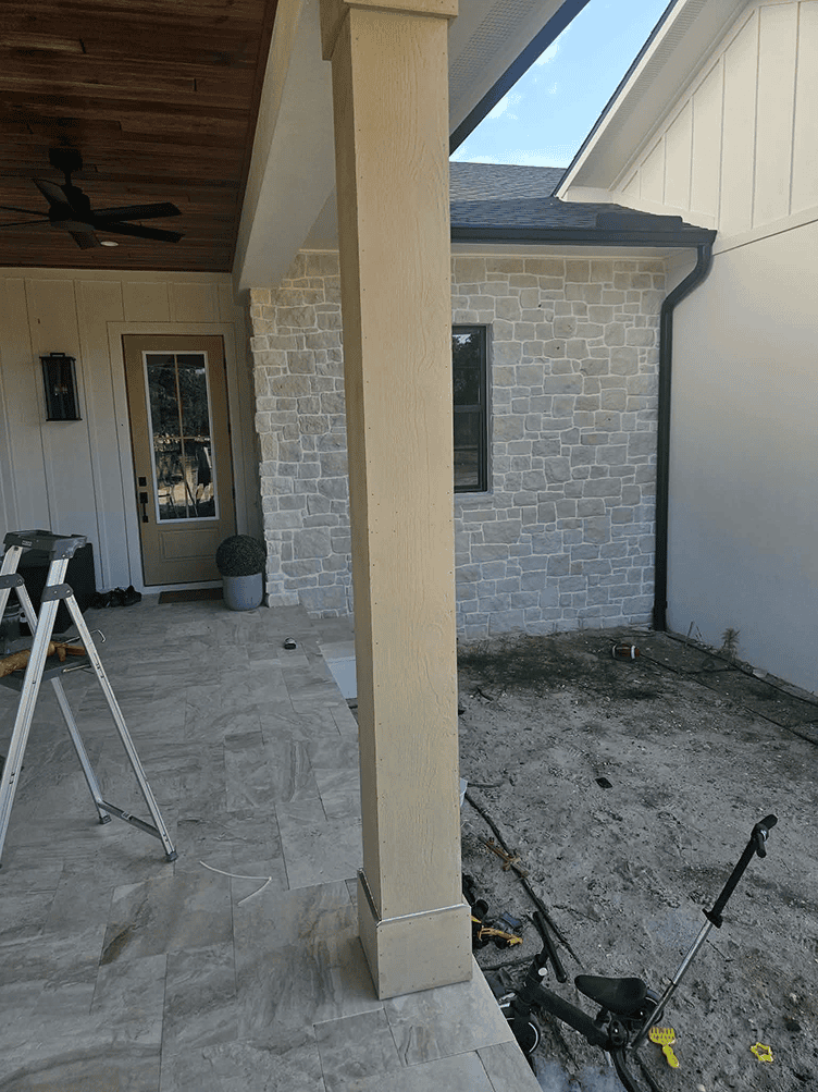 Covered patio with stone wall and lawnmower Covered patio with stone wall and lawnmower