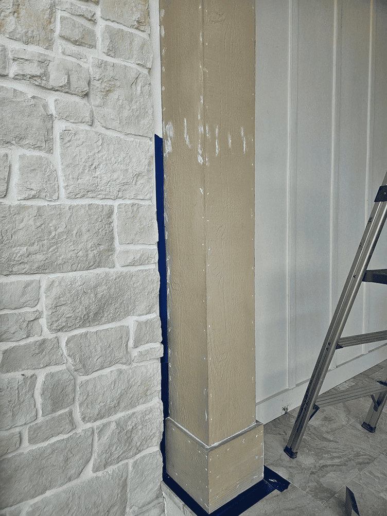 Column with fresh paint beside faux stone wall Column with fresh paint beside faux stone wall